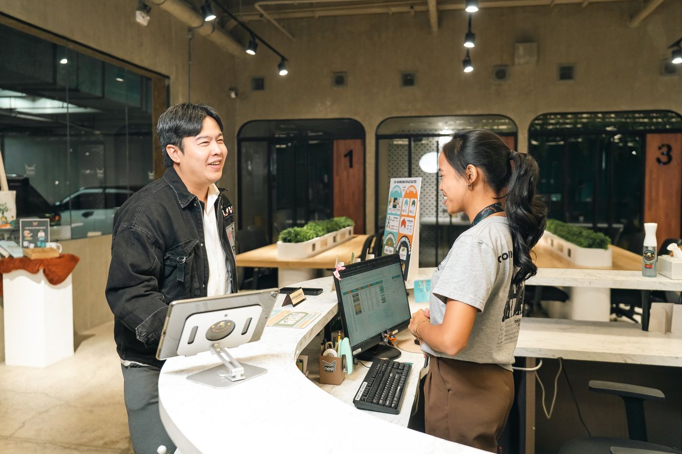 The Nest front desk, with a member checking in