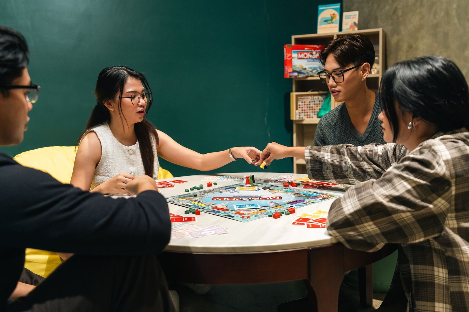 Members laughing over a board game at a round table in the lounge